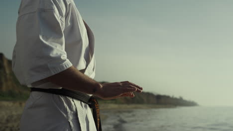 Karate-master-honing-fighting-exercises-on-seashore-close-up.-Man-training.
