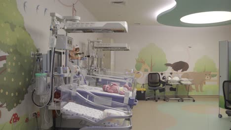 a new born baby is sleeping and sneezing in care unit