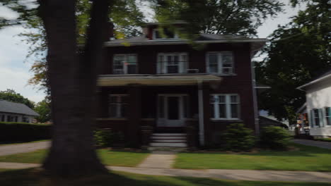 ride along typical american suburbs view from the window of the car - visible white wooden houses an