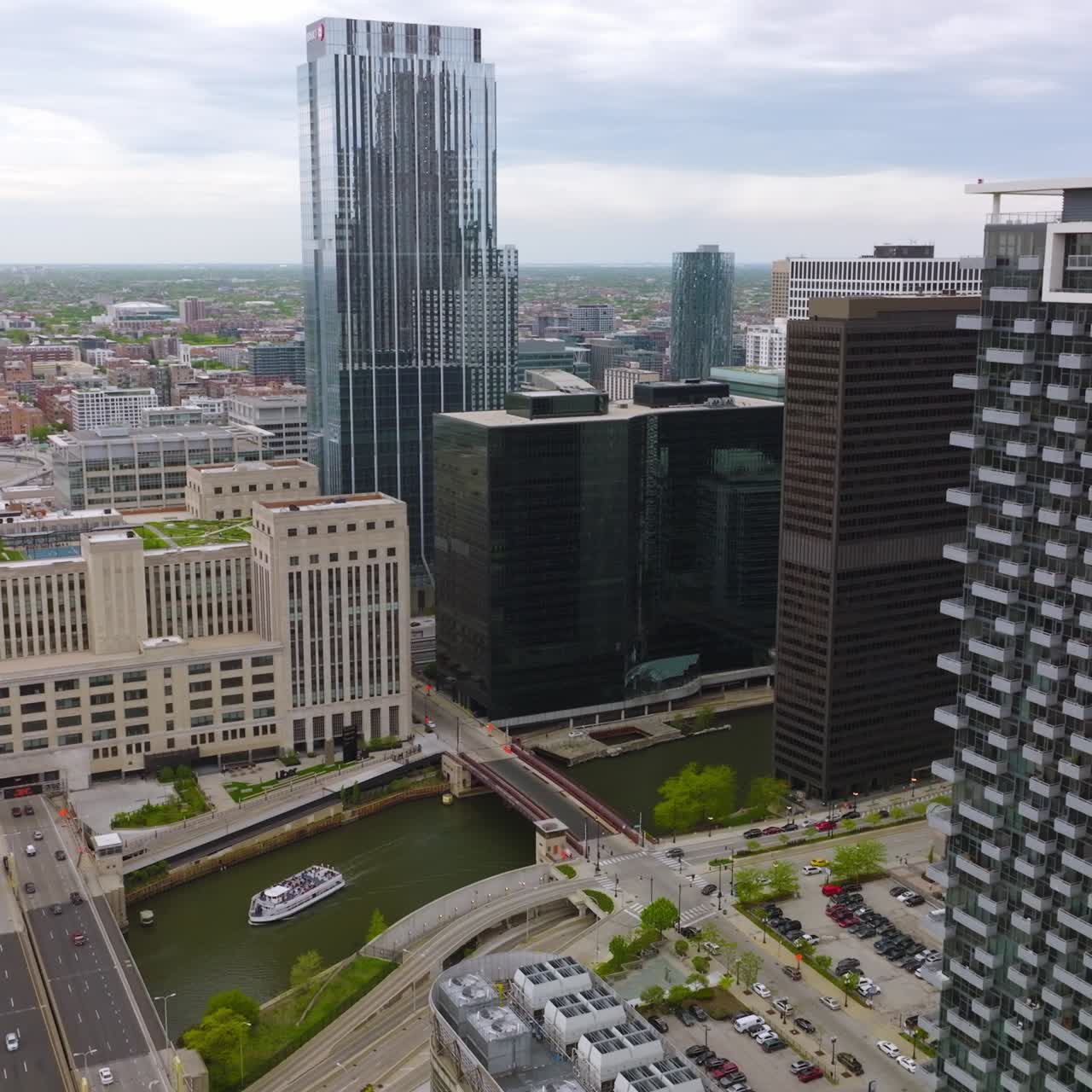 Land and water transport moving among the buildings of Chicago. Urban scenery of modern metropolis at daytime. Top view