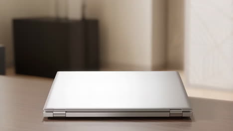 closed laptop on a wooden table, back view