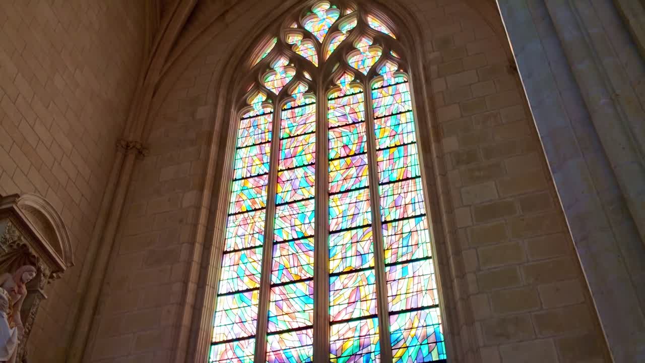 Colorata vetrata con luce che filtra all'interno della Cattedrale di San Pietro e Paolo a Nantes, Francia