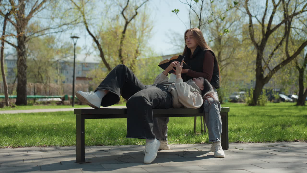 화창한 주변 환경에서 책을 읽는 친근한 야외 풍경, 쾌적한 날씨 속에서 친구들과 독서 시간을 즐기는 편안한 캠퍼스 분위기, 햇볕이 잘 드는 환경에서 편안하게 학습하는 모습