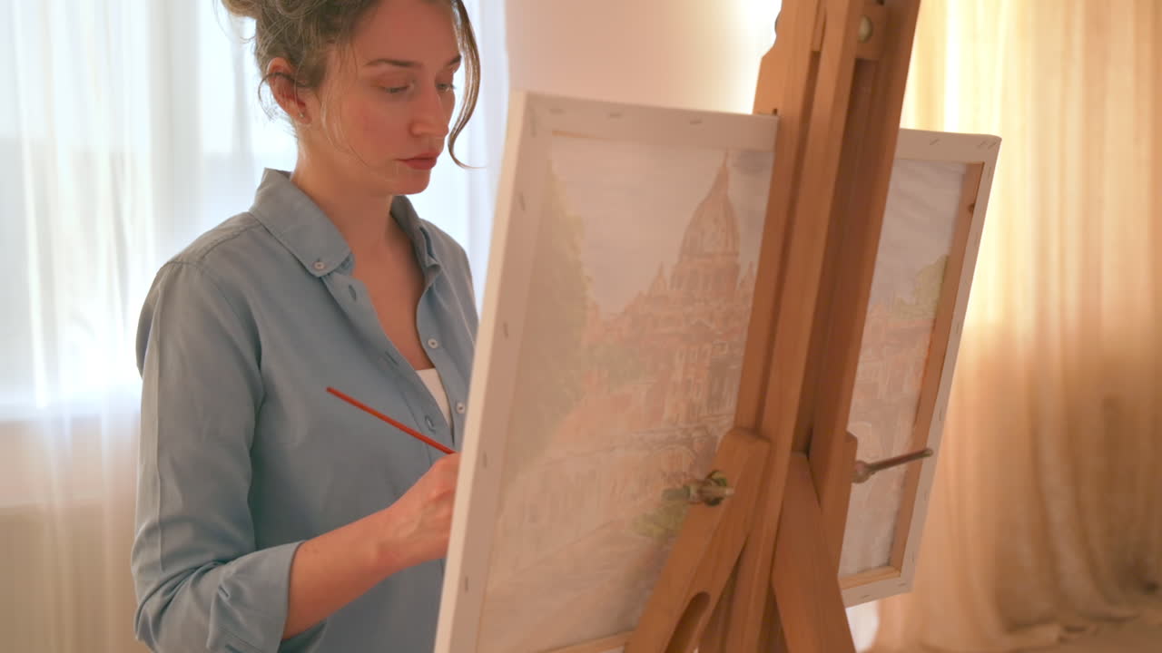 Caucasian woman painting a picture with a palette in her hands, indoors. Slow motion