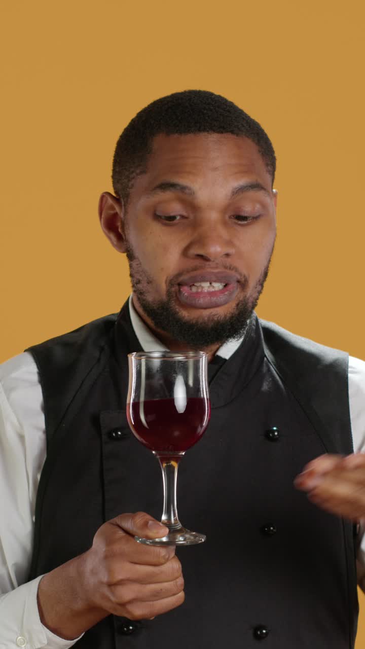 Sommelier professionista che spiega la degustazione di vino rosso in studio