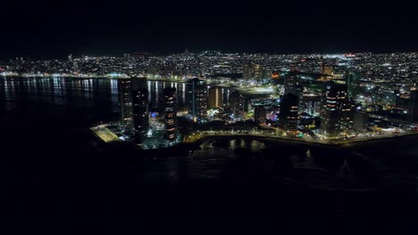 Toma-Aérea-Giratoria-De-Las-Impresionantes-Luces-Brillantes-En-La-Noche-De-Iquique,-Chile