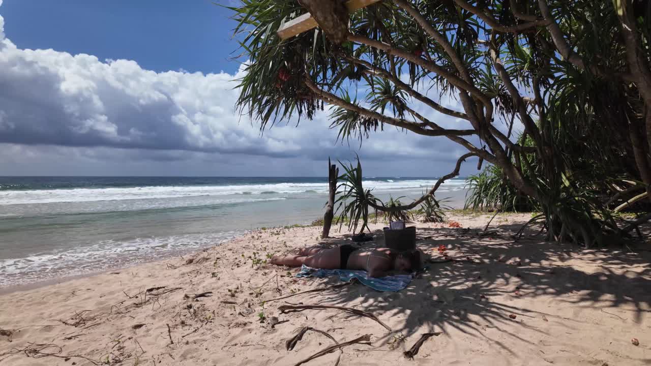Curvy plus size model on the beach shade, relaxing on sandy shore Sri Lanka