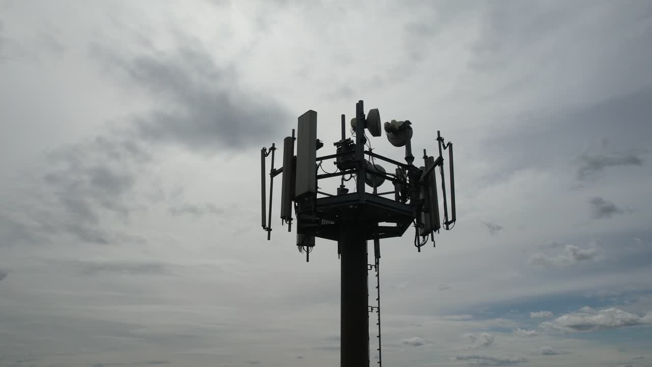 5G cellular base station tower showing multiple sector panel antennas, remote radio units, mounting brackets, and cabling, illustrating modern mobile network infrastructure for high speed wireless