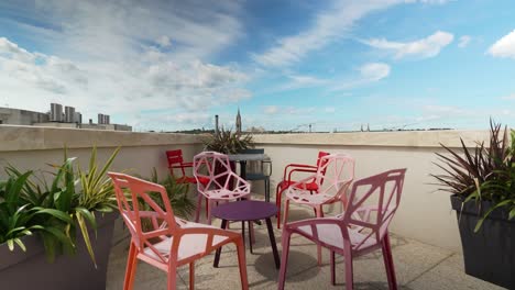 Toma-Ascendente-Lenta-Que-Revela-El-Centro-De-Nimes-Desde-Un-Balcón-En-La-Azotea-Con-Muebles-De-Jardín.