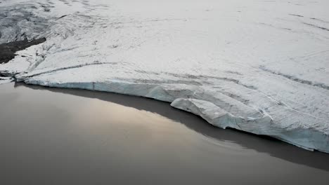 aerial view over the glacial lake of claridenfirn glacier in uri, swizerland at dusk with a view floating icebergs in the water