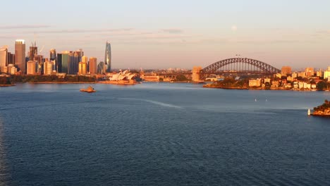 distant aerial view of sydney port jackson bay with harbour bridge and opera house at sunrise - australia