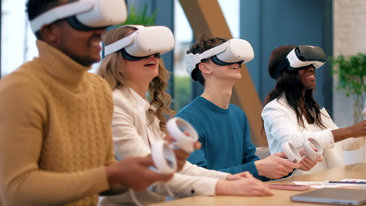 Business conference in VR in an office. Multiracial group of people. A young man teaching others how to use VR glasses and controllers, papers and gadgets on the table