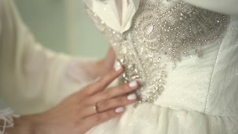 the bride strokes the wedding dress with her hand 01