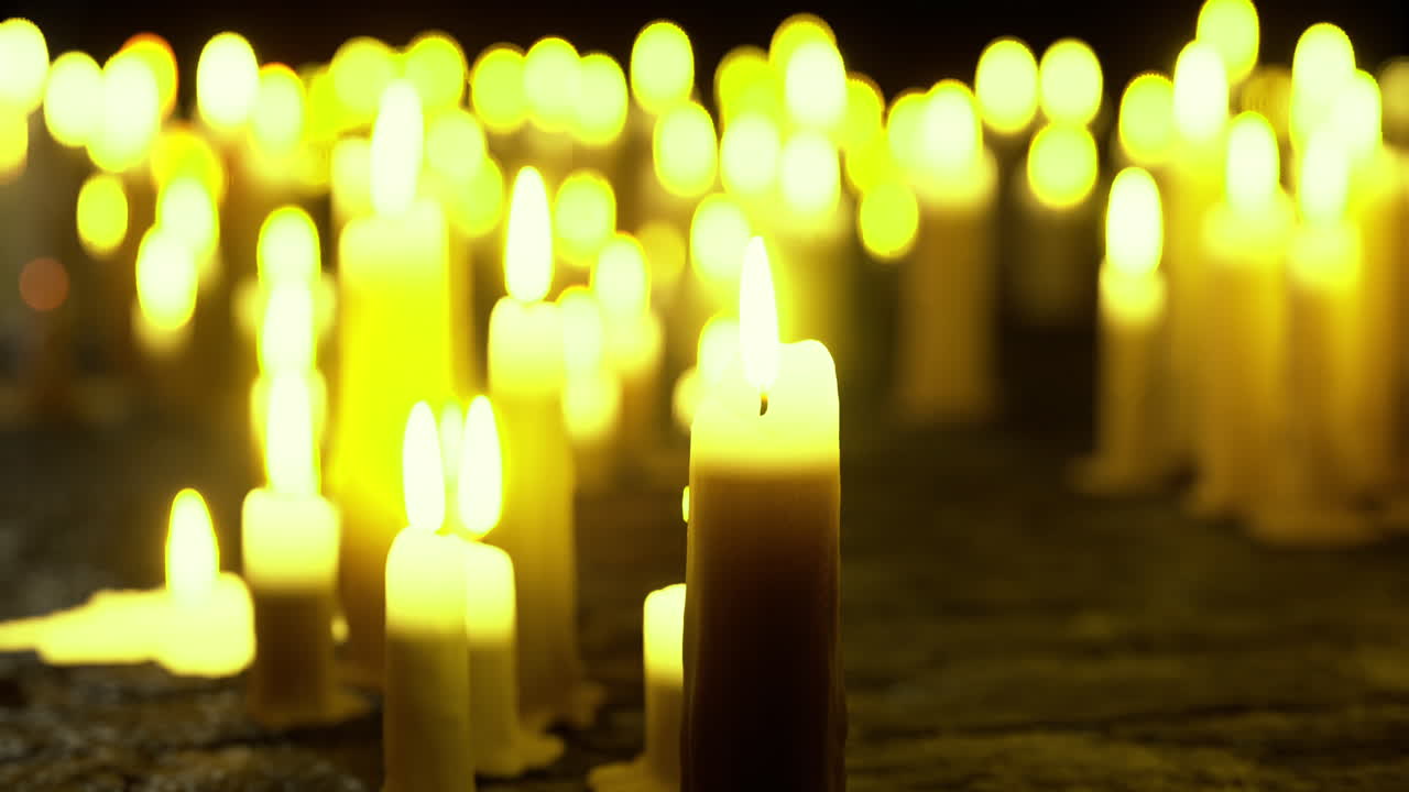 Light from numerous candles creates a warm atmosphere during a nighttime vigil