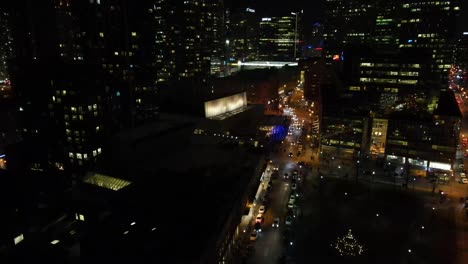 drone flying through downtown toronto at night with lots of lights on