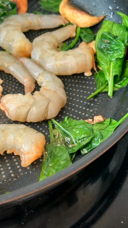shrimp and spinach cooking in pan