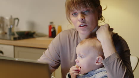 mom using laptop and talking with kids at home