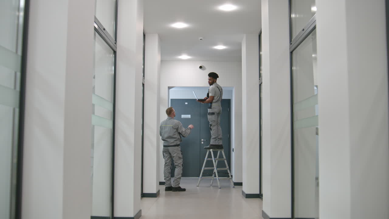 personal de mantenimiento comprobando el equipo en el pasillo de la oficina