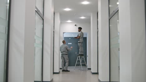 personal de mantenimiento comprobando el equipo en el pasillo de la oficina