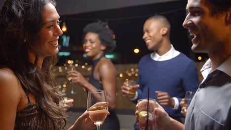 couples dancing and drinking at evening party, slow motion