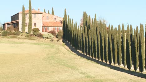 a wide shot of a farm villa with long rows of trees in tuscany italy 7