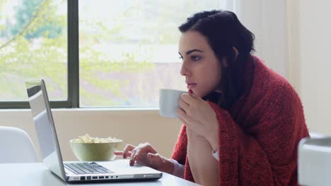 mujer hermosa usando computadora portátil mientras toma café 4k