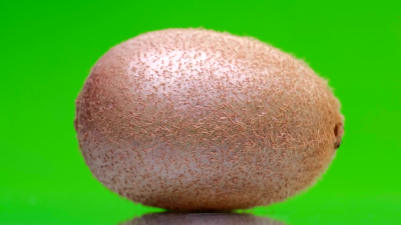 Kiwi maturo e succoso che ruota su uno schermo verde.