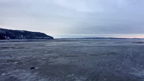 Drone-flying-over-the-river-in-winter-in-Baie-Saint-Paul