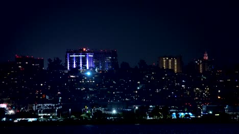 airplane flying over the san diego skyline at night