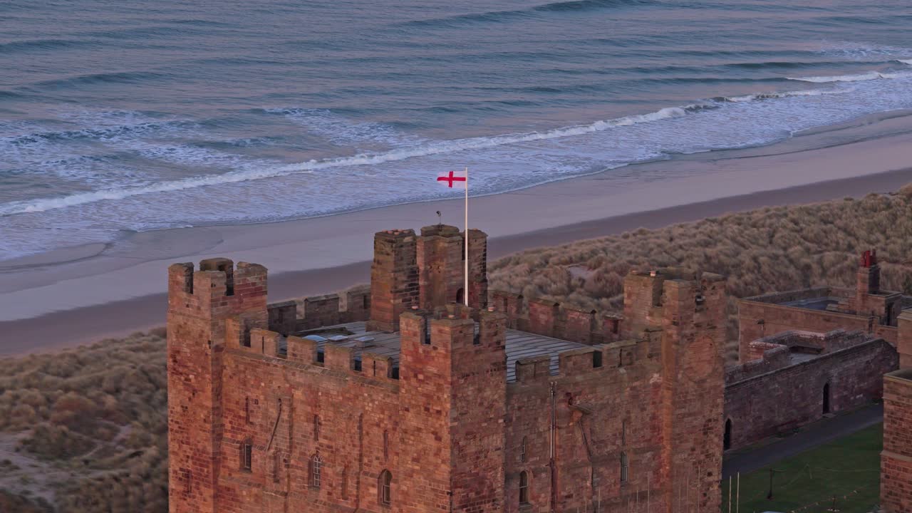 Bamburgh slott på Northumberlandkysten ved soloppgang