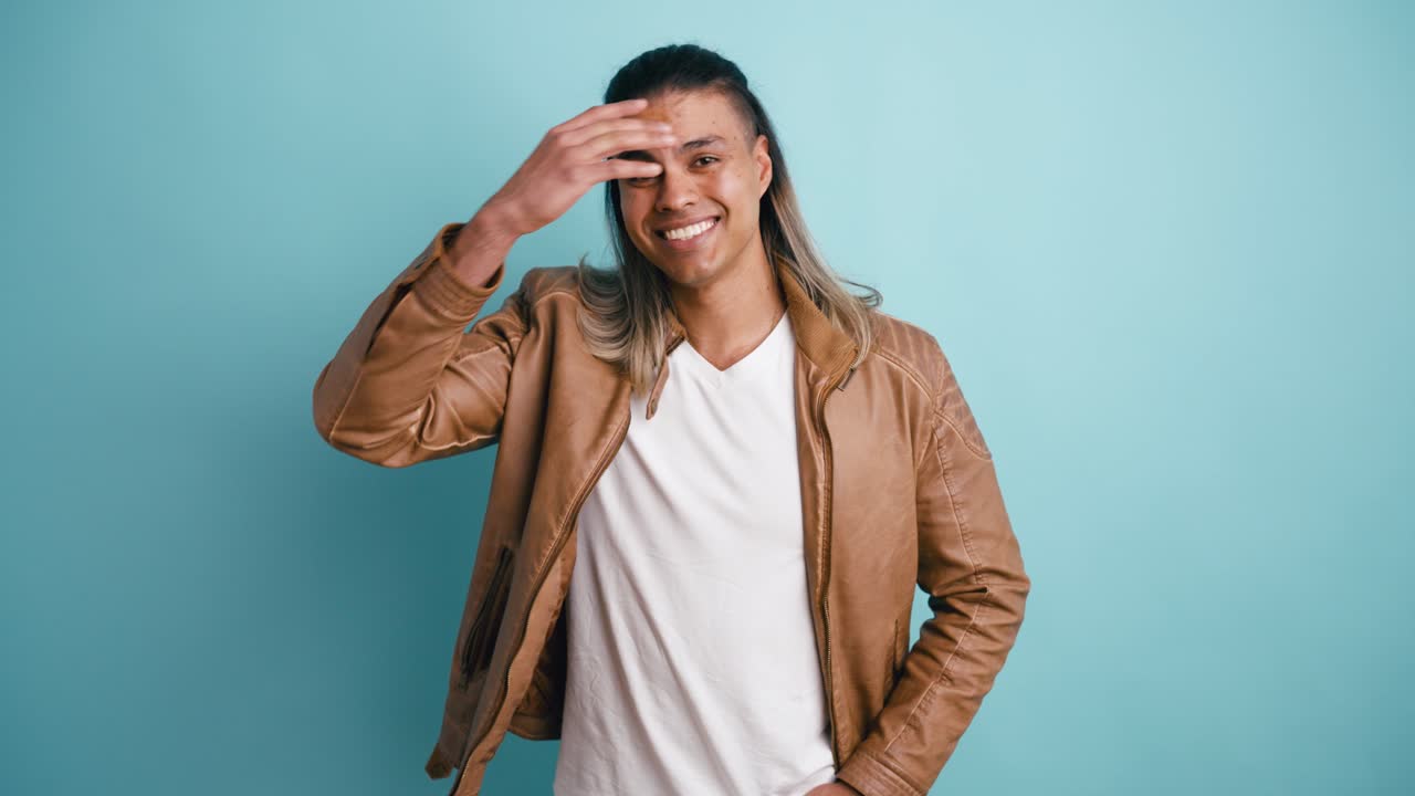 Giovane uomo felice sorridente e in posa in studio