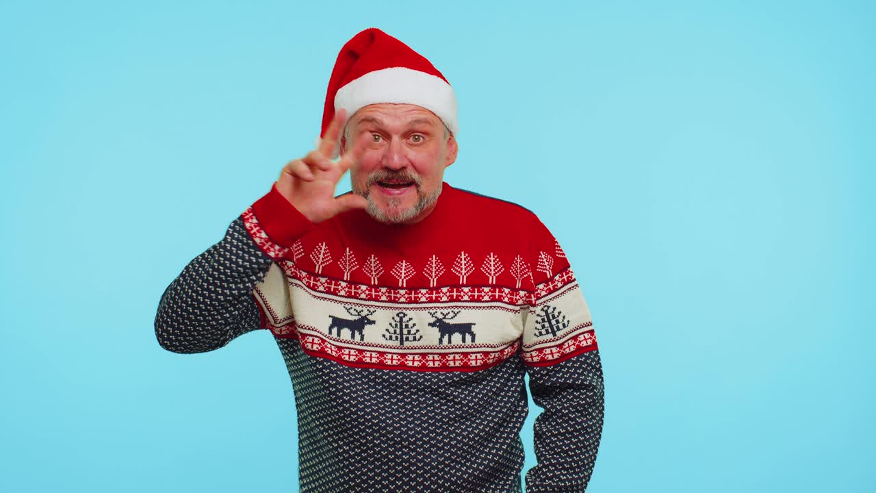 ポジティブ・マン・イン・クリスマス・セーター・ウィズ・デアーズ・ウェーブス・ハンド・パーム・イン・ハロー ジェスチャー・ウェルカムズ