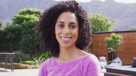 video portrait of happy biracial woman smiling to camera in garden