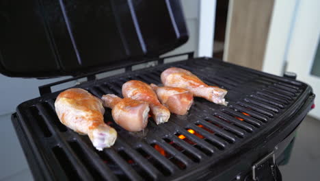 tambores de pollo condimentados crudos que se colocan en la parrilla de la barbacoa