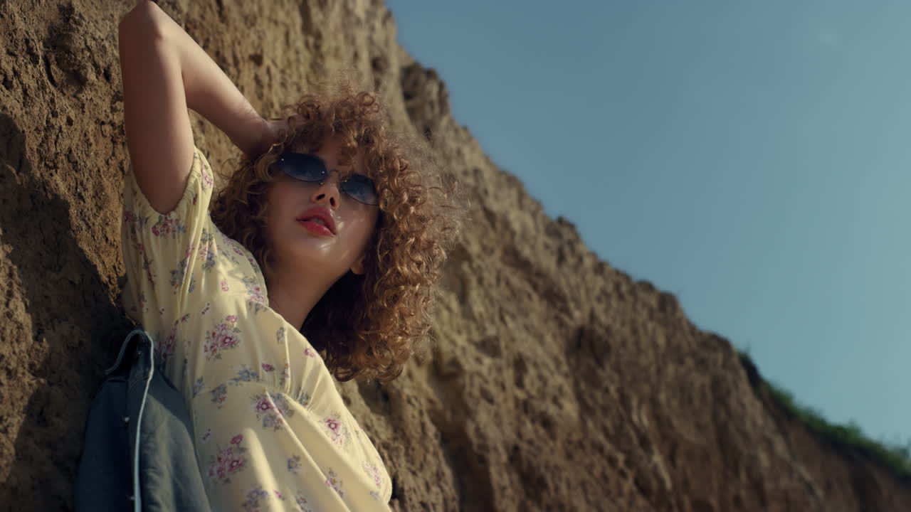 매혹적인 모델이 바가에서 빛을 비추고 서 있습니다. 여성이 포즈를 취하고 있습니다.