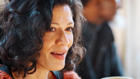 Middle-Aged-Woman-Meeting-Friends-Around-Table-In-Coffee-Shop