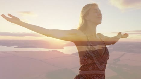 animation of landscape over caucasian woman with arms outstretched