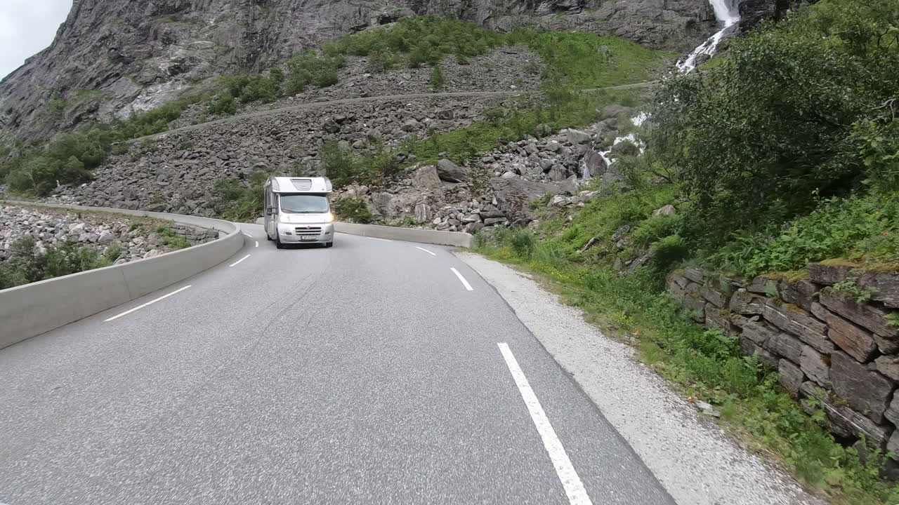 Vehicles Driving At Trollstigen Mountain Road Passing By Waterfalls In Rauma, Norway