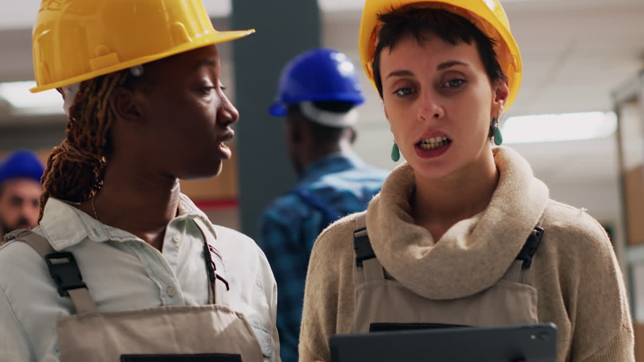 Warehouse workers discussing inventory with a tablet