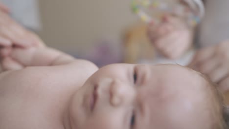 restless infant boy with blond hair lies on changing table