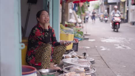 vietnamese street vendor using smartphone