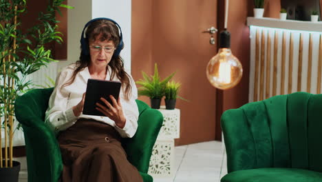 elderly woman using gadget on couch