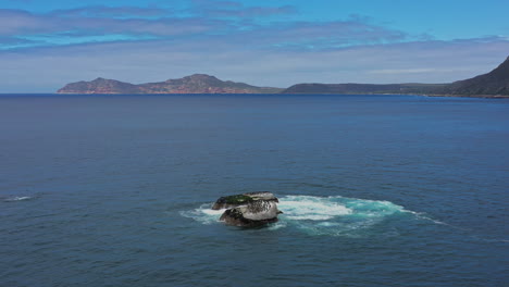 Flock-of-birds-on-a-rock-along-the-South-African-coastline-aerial-shot