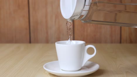 water being poured into a white cup