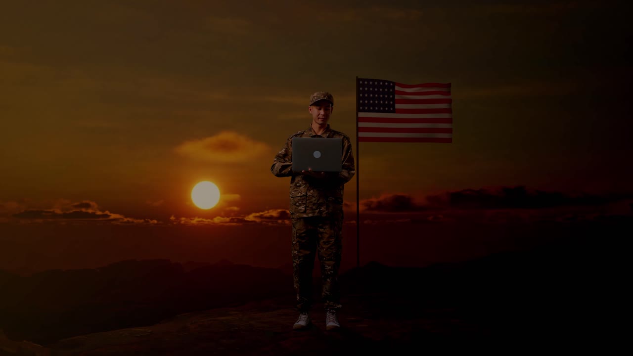 cuerpo lleno de hombre asiático soldado usando una computadora portátil mientras estaba de pie con la bandera de los estados unidos, hora del atardecer