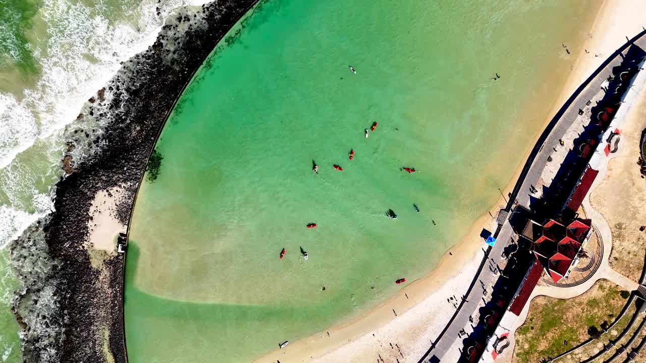 Drone pull out clip of a tidal pool in Cape Town South Africa with people leisurely enjoying the summer day