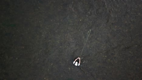 bird's eye drone shot above a man fly fishing in the provo river in the mountains of utah-4