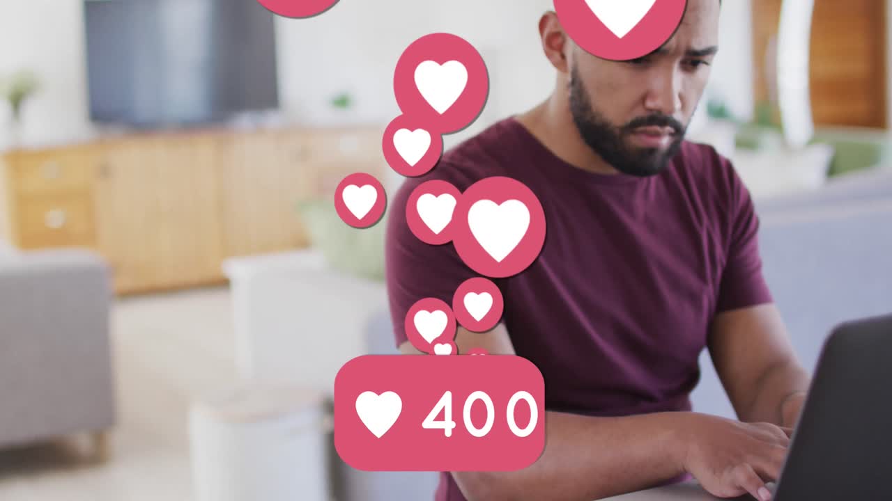 animación de números y iconos de corazones en las redes sociales sobre un hombre biracial usando una computadora portátil
