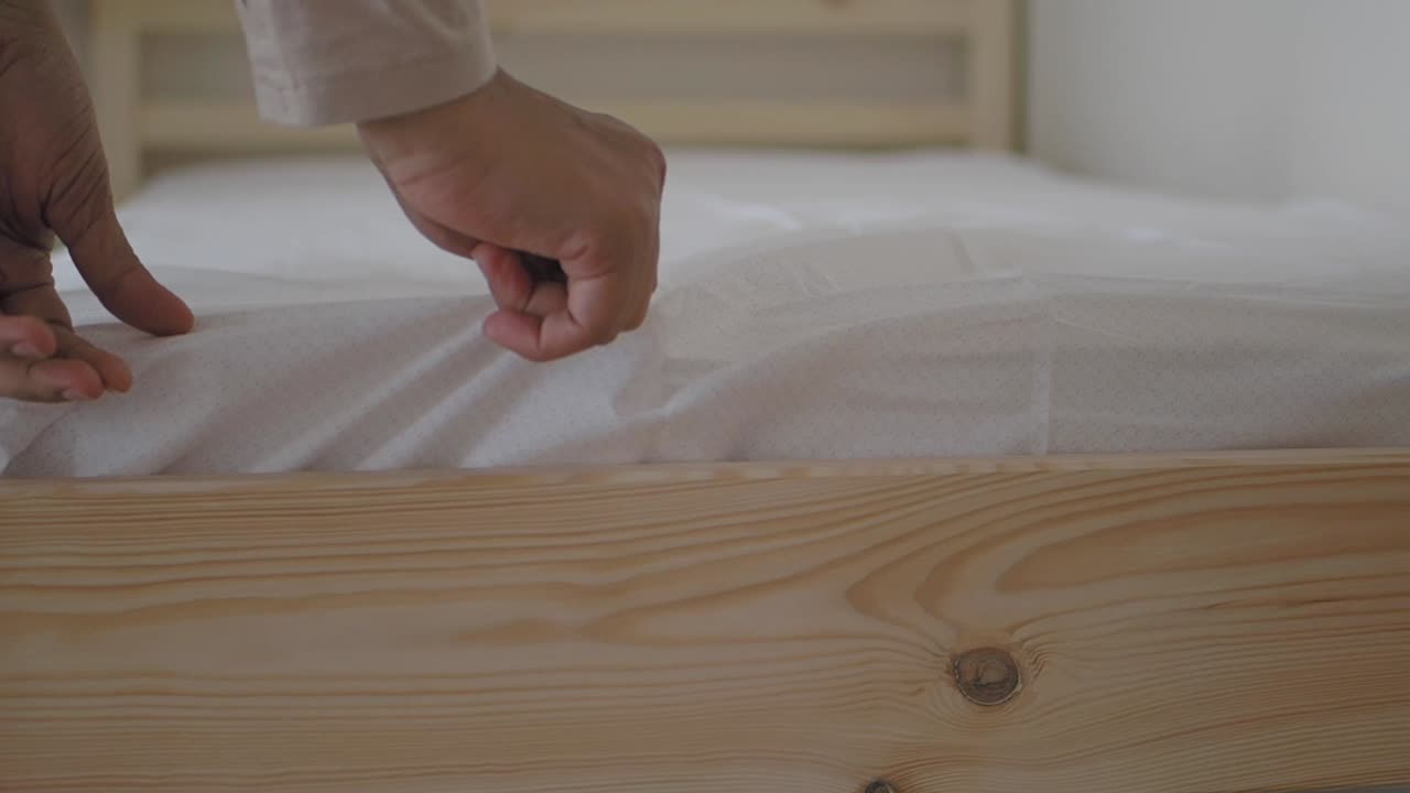 Making a bed with a white sheet