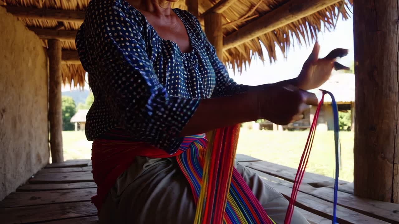 Woman Weaving Colorful Fabric in a Traditional Hut